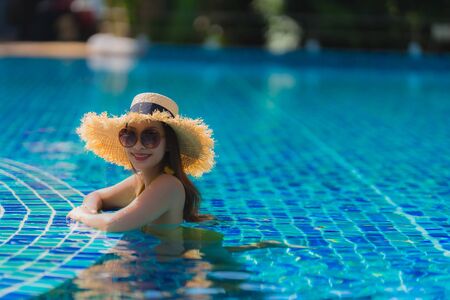 Portrait beautiful young asian woman leisure relax smile and happy around swimming pool in hotel...
