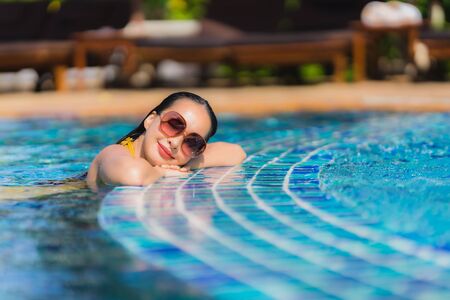 Portrait beautiful young asian woman leisure relax smile and happy around swimming pool in hotel resort for holiday vacation tripの写真素材