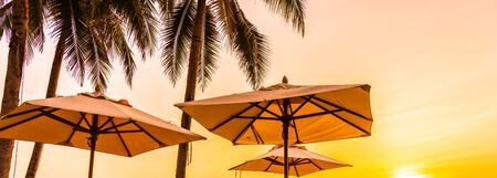 Umbrella and deck chair on the beautiful beach and sea at sunrise time for travel and vacationの写真素材