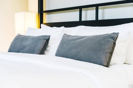 Beautiful luxury comfortable pillow on bed with light lamp decoration in bedroom interiorの写真素材