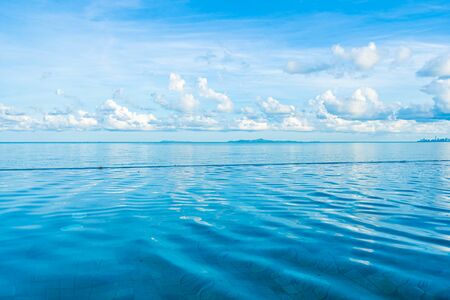 Beautiful outdoor swimming pool in hotel resort nearly sea ocean beach on white cloud blue sky for...