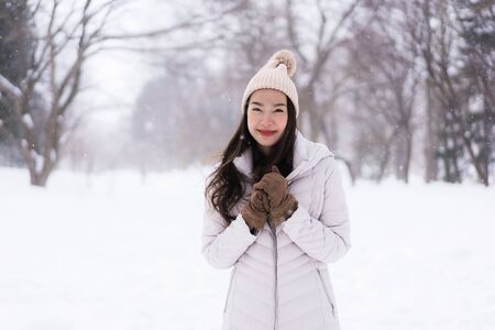 Beautiful young asian woman smiling happy with travel in snow winter season at Hokkaido Japanの写真素材
