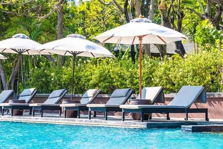 Beautiful landscape of sea ocean on sky with umbrella and chair around luxury outdoor swimming pool...