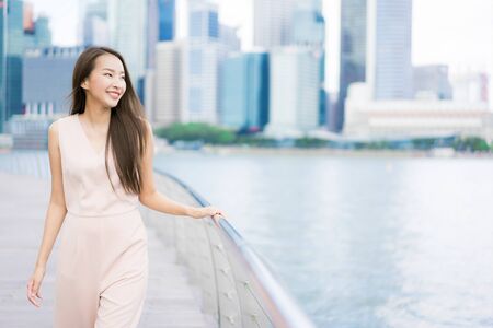 Beautiful asian woman smile and happy to travel in singapore cityの写真素材