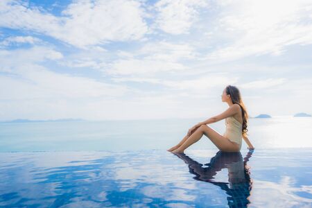 Portrait young asian woman relax smile happy around swimming pool in hotel and resort for holiday vacation travel conceptの写真素材