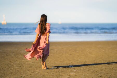 Portrait young beautiful asian woman walk smile and happy on the beach sea and ocean for leisure travel in holiday vacationの写真素材