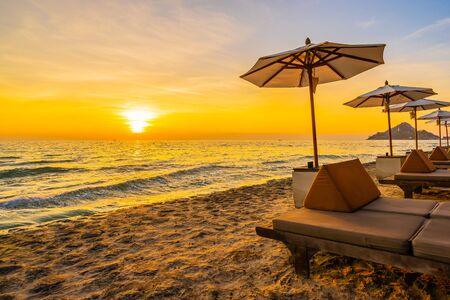 Umbrella and chair with pillow around beautiful landscape of beach and sea at sunrise or sunset time for holiday vacation and travelの写真素材
