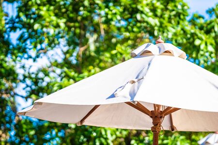 Beautiful outdoor tropical nature with white umbrella around beach and sea on blue sky for leisure relax and vacationの写真素材