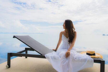 Portrait young asian woman relax smile happy around swimming pool in hotel and resort for holiday vacation travel conceptの写真素材