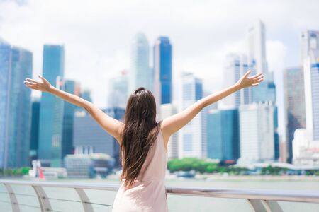 Beautiful asian woman smile and happy to travel in singapore cityの写真素材