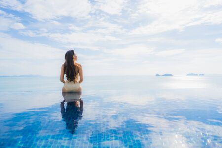 Portrait young asian woman relax smile happy around swimming pool in hotel and resort for holiday vacation travel conceptの写真素材
