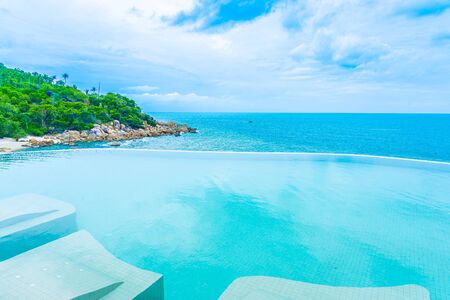Beautiful outdoor infinity swimming pool in hotel resort with sea ocean view and white cloud blue sky for holiday vacation and travelの写真素材