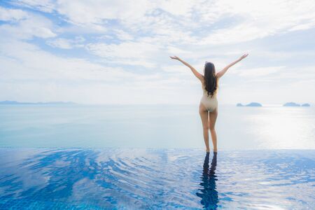Portrait young asian woman relax smile happy around swimming pool in hotel and resort for holiday vacation travel conceptの写真素材