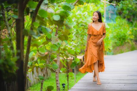 Portrait beautiful young asian woman walk on path walk in the garden with happy smile relaxの写真素材