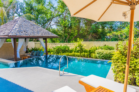 Umbrella and chair around swimming pool neary beautiful landscape of sea ocean beach with blue sky...