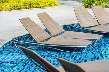 Empty chair for take a seat and relax around outdoor swimming pool for holiday vacation concept