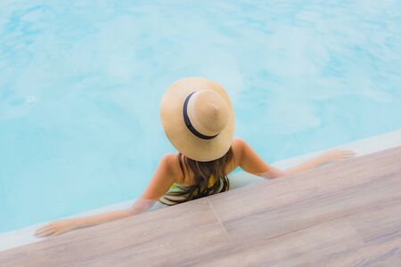 Portrait asian beautiful young woman happy smile relax around outdoor swimming pool in holiday vacation travel tripの写真素材