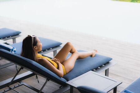 Portrait asian beautiful young woman happy smile relax around outdoor swimming pool in holiday vacation travel tripの写真素材