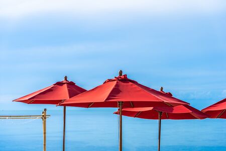Beautiful outdoor tropical beach sea ocean with umbrella chair and lounge deck around there on white cloud blue sky background for holiday vacation travelの写真素材