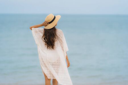 Portrait beautiful young asian woman smile happy relax on the beach sea ocean in holiday vacation travelの写真素材