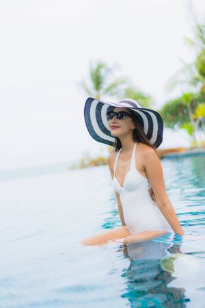 Portrait beautiful young asian woman smile happy relax around swimming pool in hotel resort for holiday vacationの写真素材