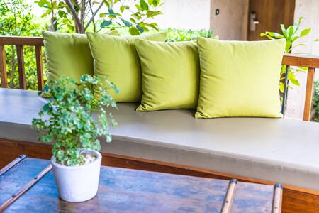 Vase plant on table decoration with pillow on sofa chair outdoor viewの写真素材