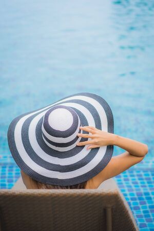 Portrait beautiful young asian woman smile happy relax around swimming pool in hotel resort for holiday vacationの写真素材