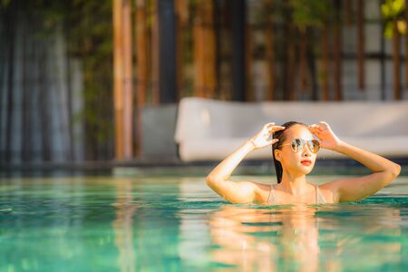 Portrait young beautiful asian woman happy smile and relax in swimming pool around hotel resort for leisure travel in holiday vacationの写真素材