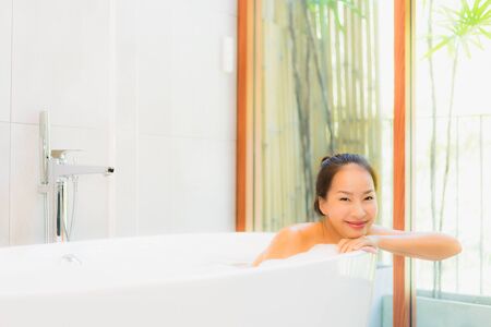 Portrait young beautiful asian woman take a bath in bathtub for leisure relax and in bathroom interiorの写真素材