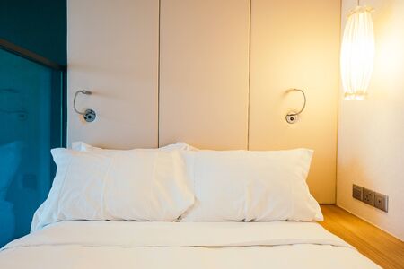 White comfortable pillow on bed decoration in hotel bed room interiorの写真素材