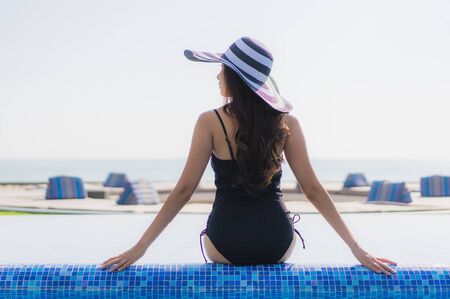 Beautiful young asian woman happy smile and relax in swimming pool at resort hotel for leisure travel and vacationの写真素材