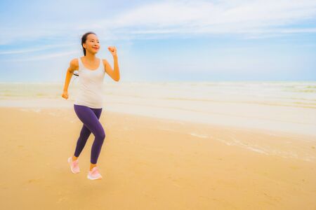 Portrait beautiful young sport asian woman exercise by run and jogging on the outdoor nature beach and sea for healthyの写真素材