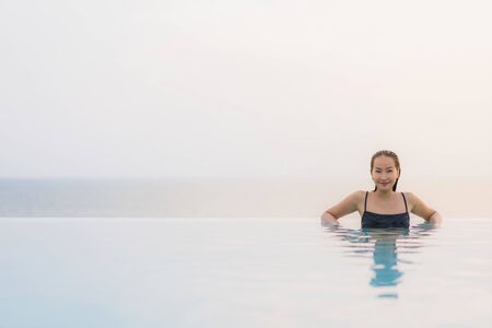 Portrait beautiful young asian woman happy smile relax around swimming pool in hotel resort for...