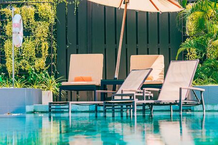 Beautiful outdoor swimming pool in hotel and resort with chair and deck for leisure vacation and...
