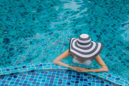 Portrait beautiful young asian woman smile happy relax around swimming pool in hotel resort for holiday vacationの写真素材