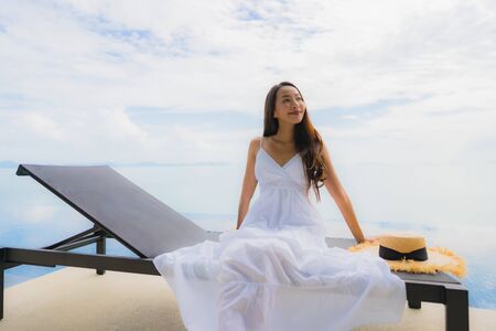 Portrait young asian woman relax smile happy around swimming pool in hotel and resort for holiday vacation travel conceptの写真素材