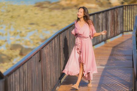 Portrait beautiful young asian woman looking sea beach ocean for relax in holiday vacation travel conceptの写真素材