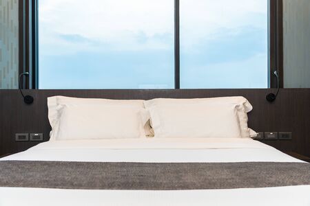 Beautiful luxury comfortable white pillow and blanket on bed with light lamp furniture decoration in...