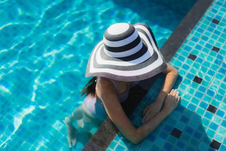 Beautiful portrait asian woman relax happy smile around outdoor swimming pool in holiday vacation