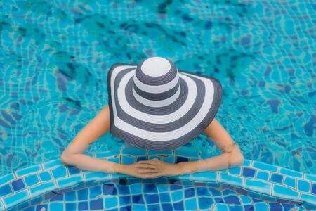 Portrait beautiful young asian woman smile happy relax around swimming pool in hotel resort for holiday vacationの写真素材