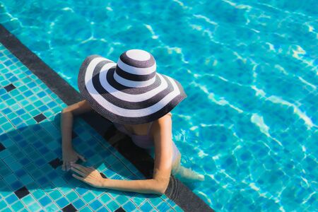 Beautiful portrait asian woman relax happy smile around outdoor swimming pool in holiday vacationの写真素材