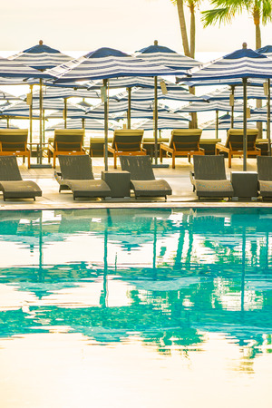 Umbrella and chair sofa around outdoor swimming pool in hotel resort for travel holiday vacationのeditorial素材
