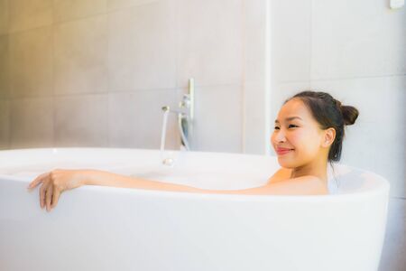 Portrait young beautiful asian woman take a bath in bathtub for leisure relax and in bathroom interiorの写真素材