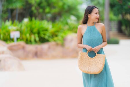 Beautiful portrait young asian woman happy smile relax with walk in the tropical gardenの写真素材