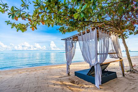 Empty bed chair and lounge on the tropical beach sea ocean with white cloud on blue sky for leisure travel and in holiday vacationの写真素材