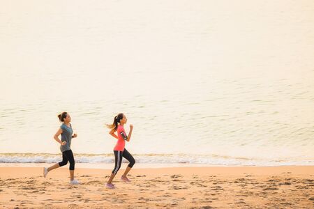 Portrait beautiful young sport asian woman running and exercise on the beach near sea and ocean at sunrise or sunset time for healthy conceptの写真素材