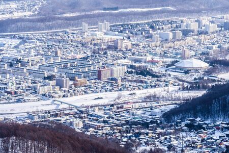 Beautiful architecture building with mountain landscape in winter season Sapporo city Hokkaido Japanの写真素材