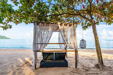 Empty bed chair and lounge on the tropical beach sea ocean with white cloud on blue sky for leisure travel and in holiday vacationの写真素材