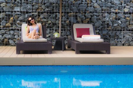 Beautiful portrait asian woman relax happy smile around outdoor swimming pool in holiday vacation