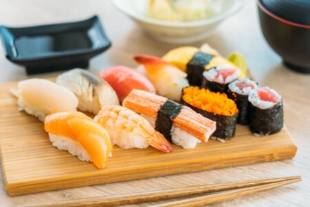Salmon tuna shell shrimp and other meat sushi maki on wood tray with sauce and soup - Japanese food styleの写真素材
